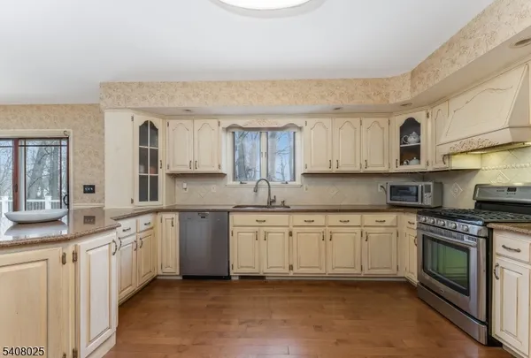 a kitchen with granite countertop white cabinets and white appliances