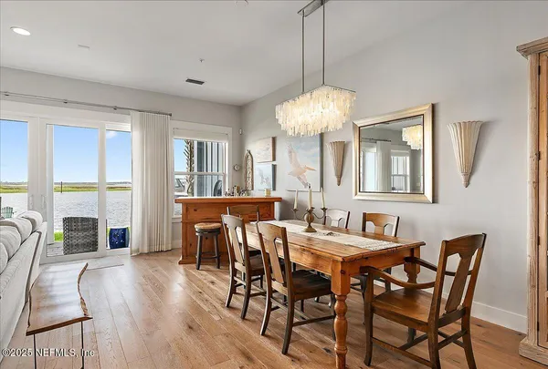 a living room with furniture kitchen view and a chandelier