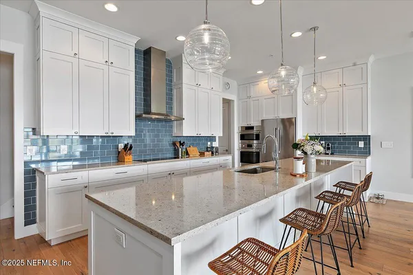 a large kitchen with stainless steel appliances lots of counter space and a sink