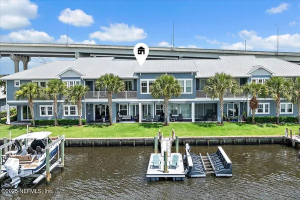 a front view of a house with a garden and lake view