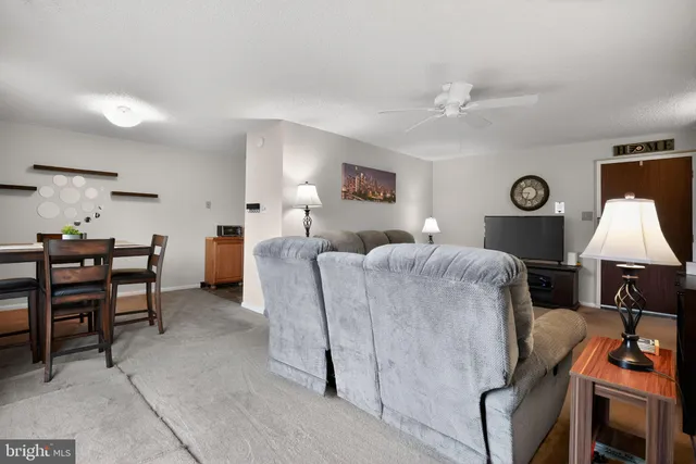a living room with furniture a window and a lamp