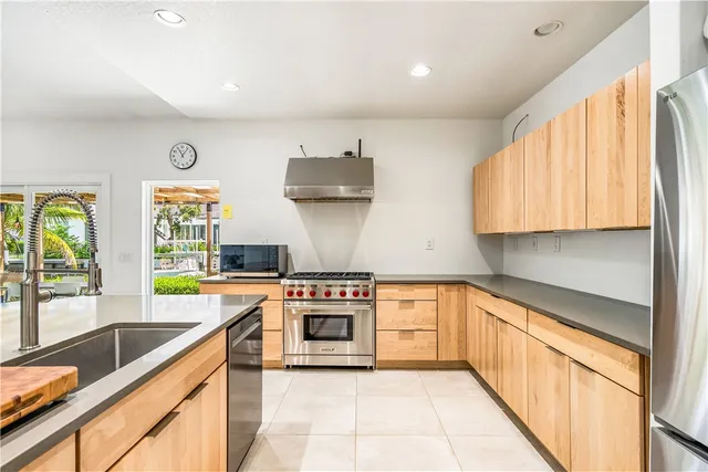 a kitchen with stainless steel appliances granite countertop a stove a sink and a microwave