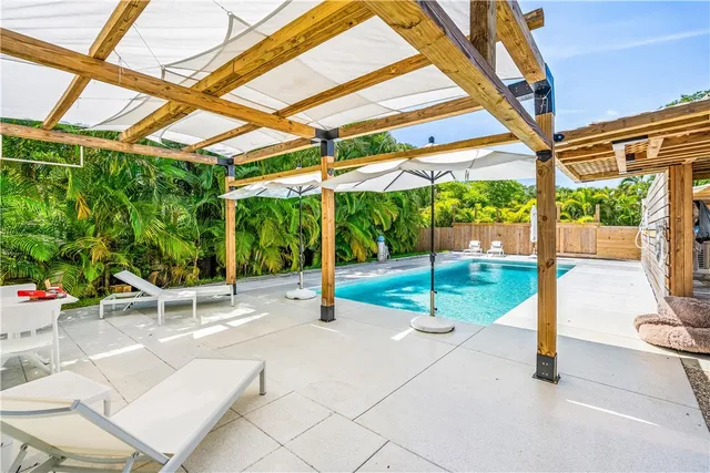 a view of a patio with a table and chairs under an umbrella