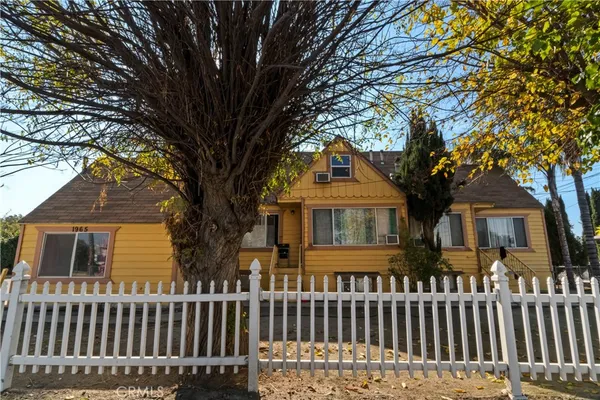 a view of a house with a yard and potted plants