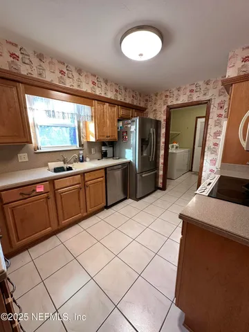 a kitchen with stainless steel appliances a stove a sink and a refrigerator