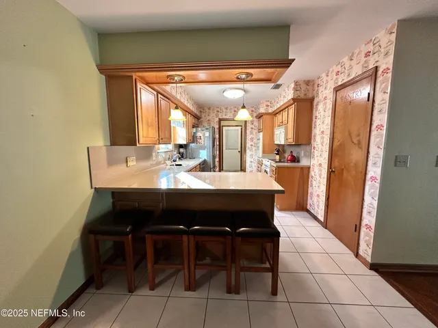 a dining room with stainless steel appliances a table and chairs