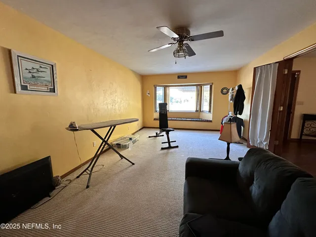 a view of a livingroom with furniture and a gym cycle