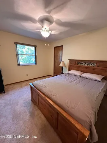a bed sitting in a bedroom and chandelier