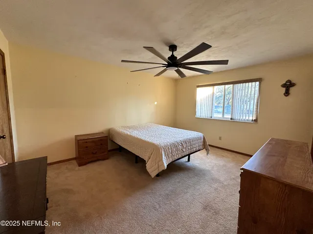 a bedroom with a bed and a ceiling fan