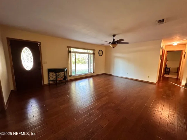a view of a livingroom with wooden floor and a staircase