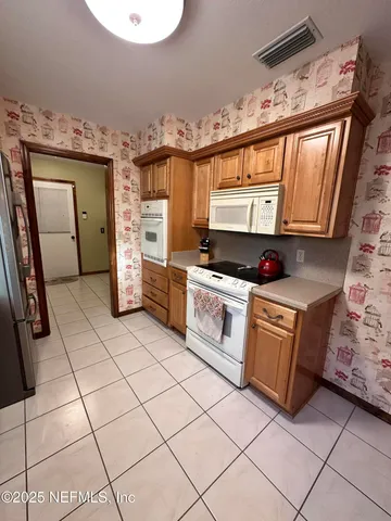 a kitchen with granite countertop a stove a sink and a microwave