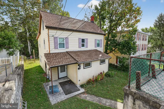 a aerial view of a house with a yard table and chairs