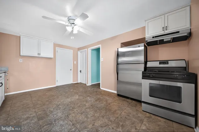 a kitchen with a refrigerator stove and white cabinets