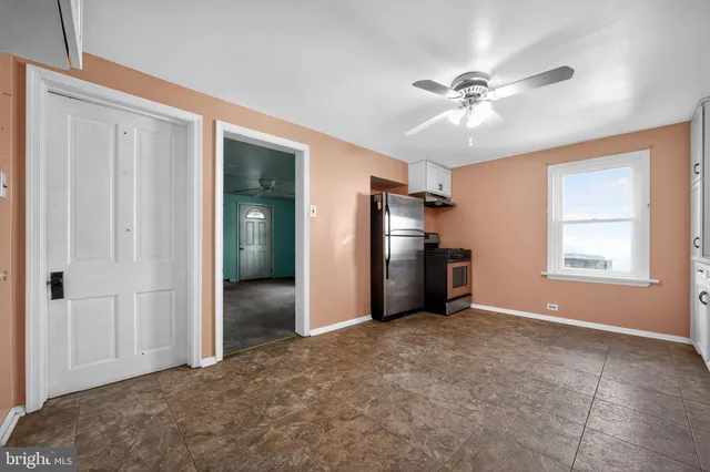 a view of empty room with window and ceiling fan