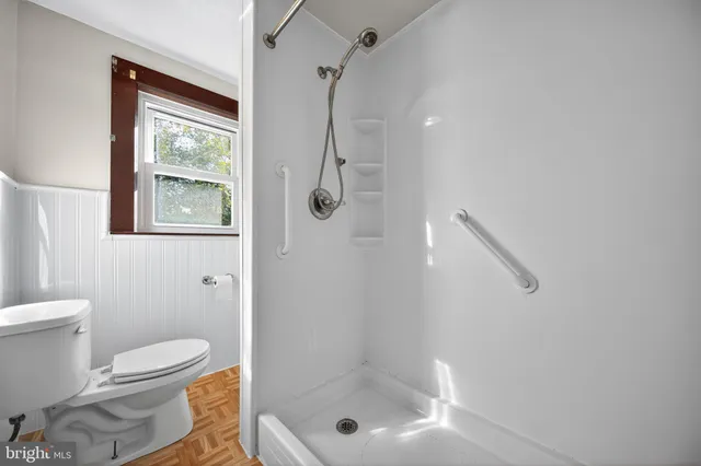 a bathroom with a shower a toilet and a shower