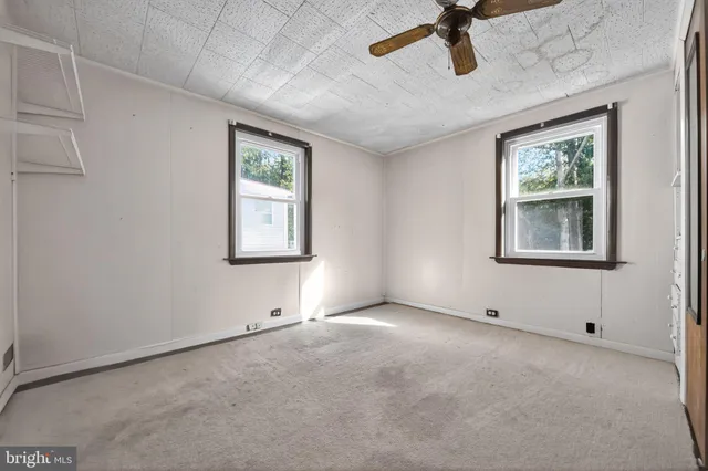 an empty room with windows and cabinet