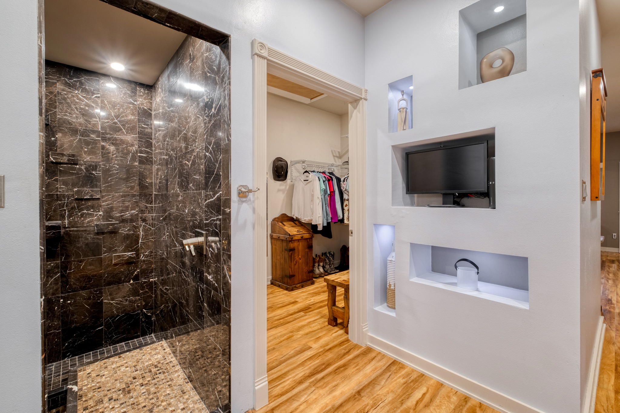 1474 County Rd B Lexington, TX 78947 - Photo 9 of 34 A lavish walk-in shower with exquisite dark marble tiling stands adjacent to a well-organized closet.