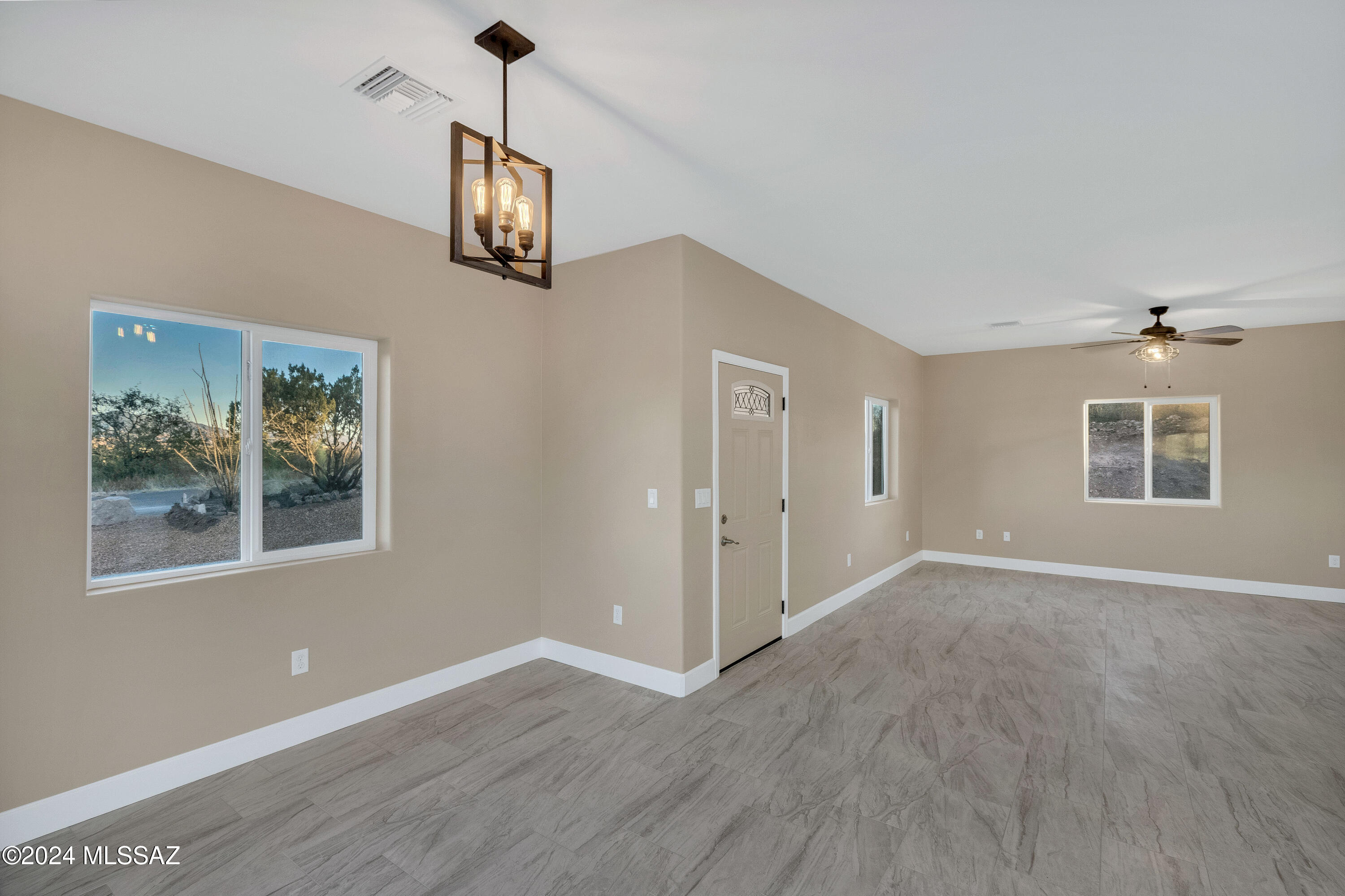 221 Paseo Mascota Rio Rico, AZ 85648 - Photo 13 of 45 a view of an empty room with wooden floor and a window
