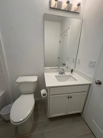 a bathroom with a sink mirror and toilet
