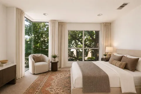 a bedroom with a bed and a large window