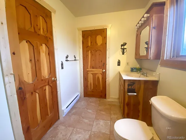 a bathroom with a sink a toilet a mirror and shower