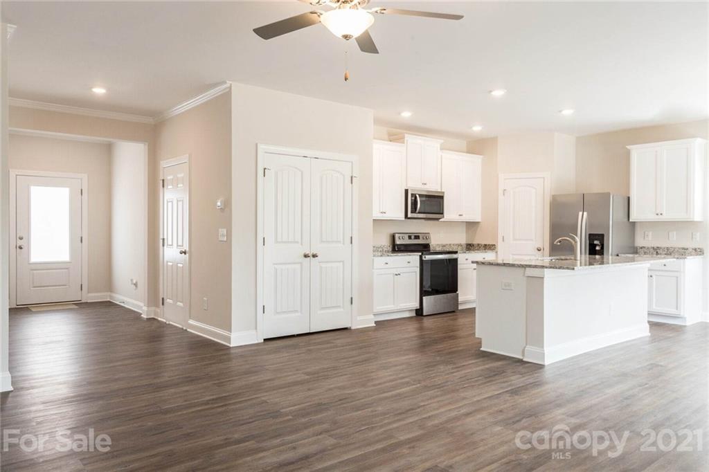 2106 Osten Run Monroe, NC 28110 - Photo 2 of 7 an open kitchen with white cabinets wooden floor and stainless steel appliances