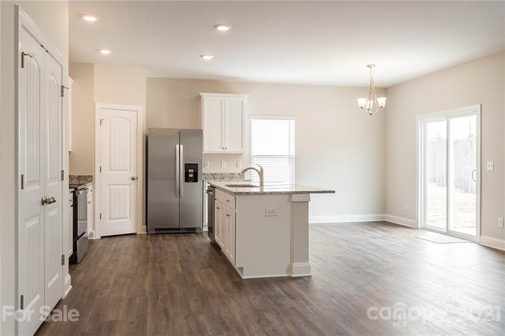 2106 Osten Run Monroe, NC 28110 - Photo 4 of 7 a large kitchen with a refrigerator a sink and cabinets