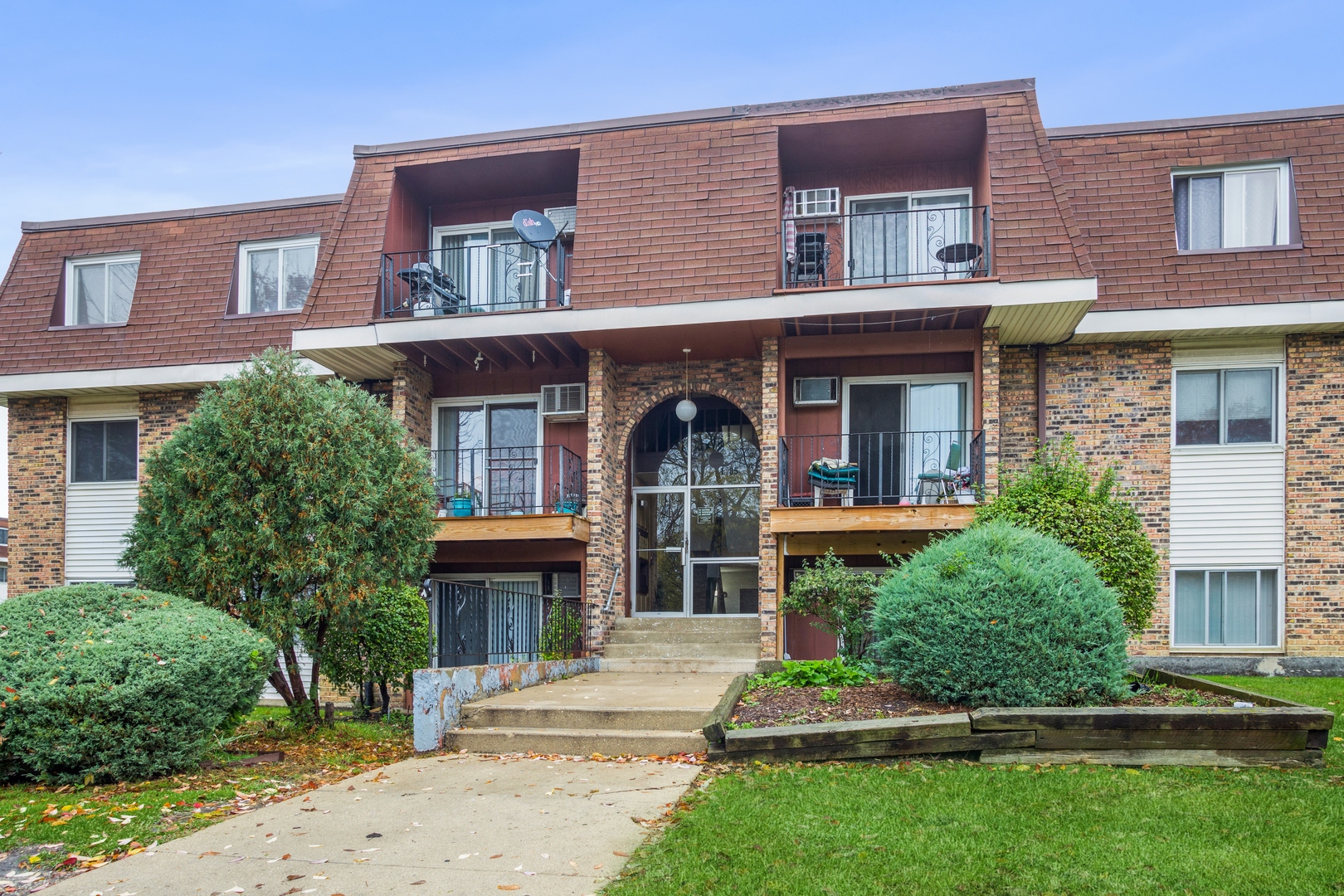 a front view of a house with a garden and plants