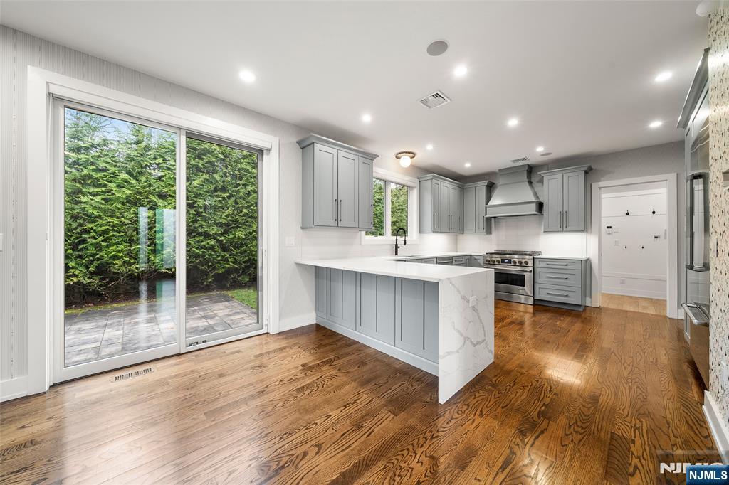 55 Cedar Street Cresskill, NJ 07626 - Photo 13 of 40 a kitchen with stainless steel appliances granite countertop a refrigerator a sink dishwasher a oven and a large window with wooden floor