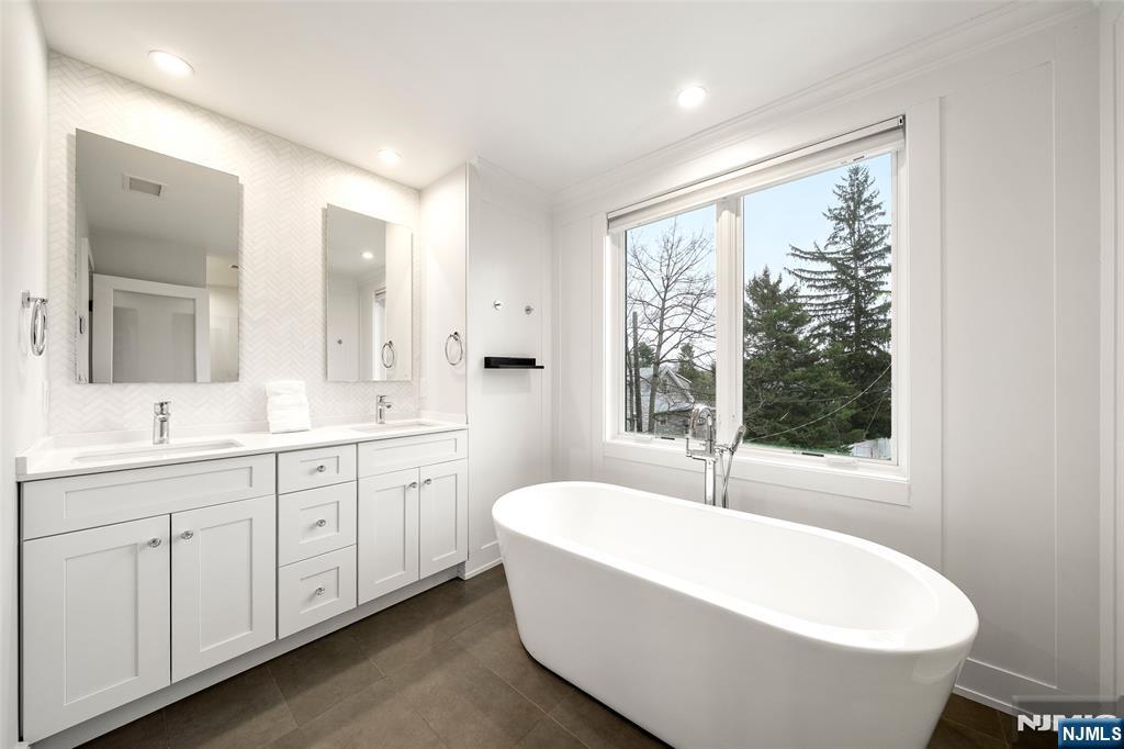 55 Cedar Street Cresskill, NJ 07626 - Photo 21 of 40 a bathroom with a large tub a sink and window