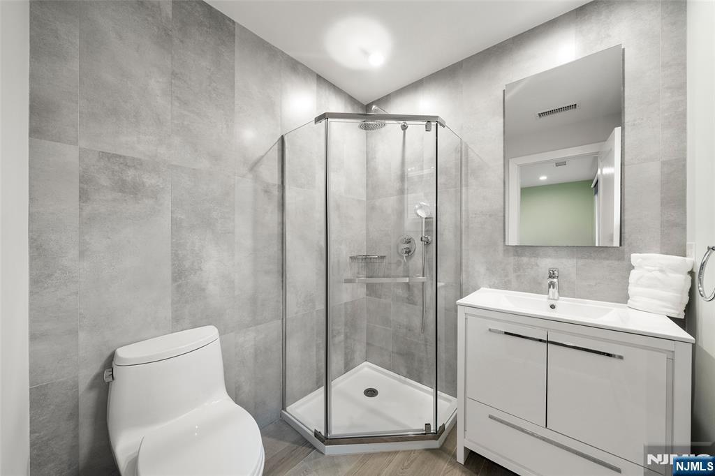 55 Cedar Street Cresskill, NJ 07626 - Photo 26 of 40 a bathroom with a toilet a sink and glass door