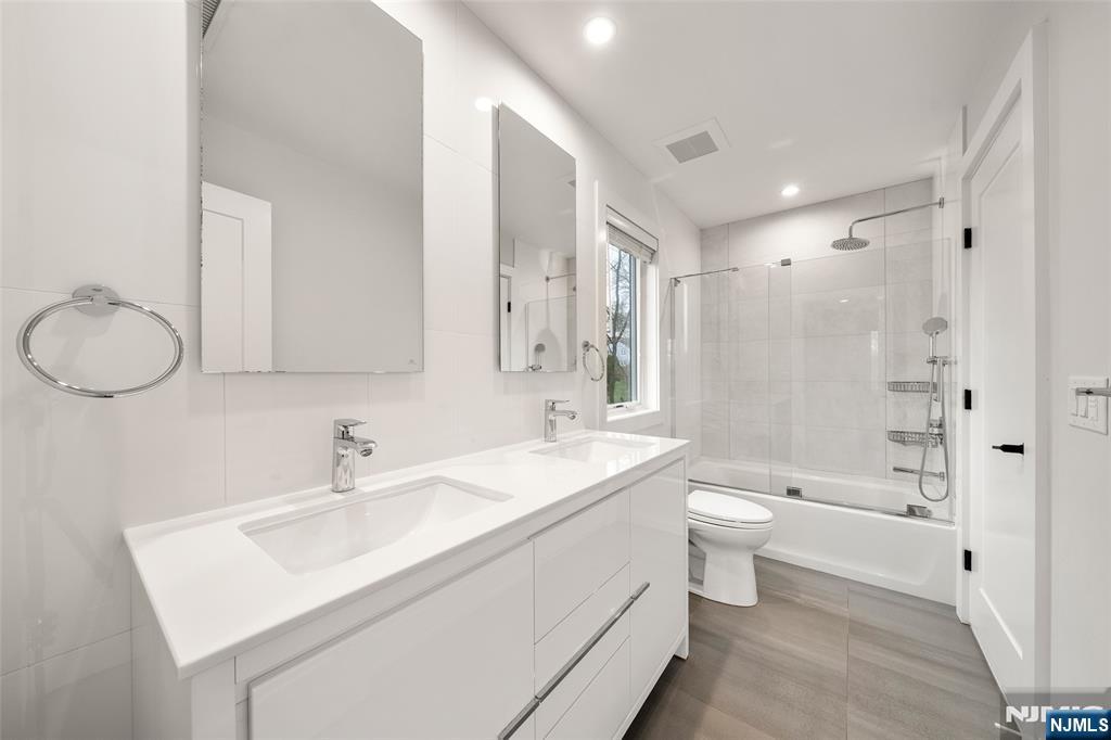 55 Cedar Street Cresskill, NJ 07626 - Photo 29 of 40 a bathroom with a double vanity sink toilet mirror and bathtub