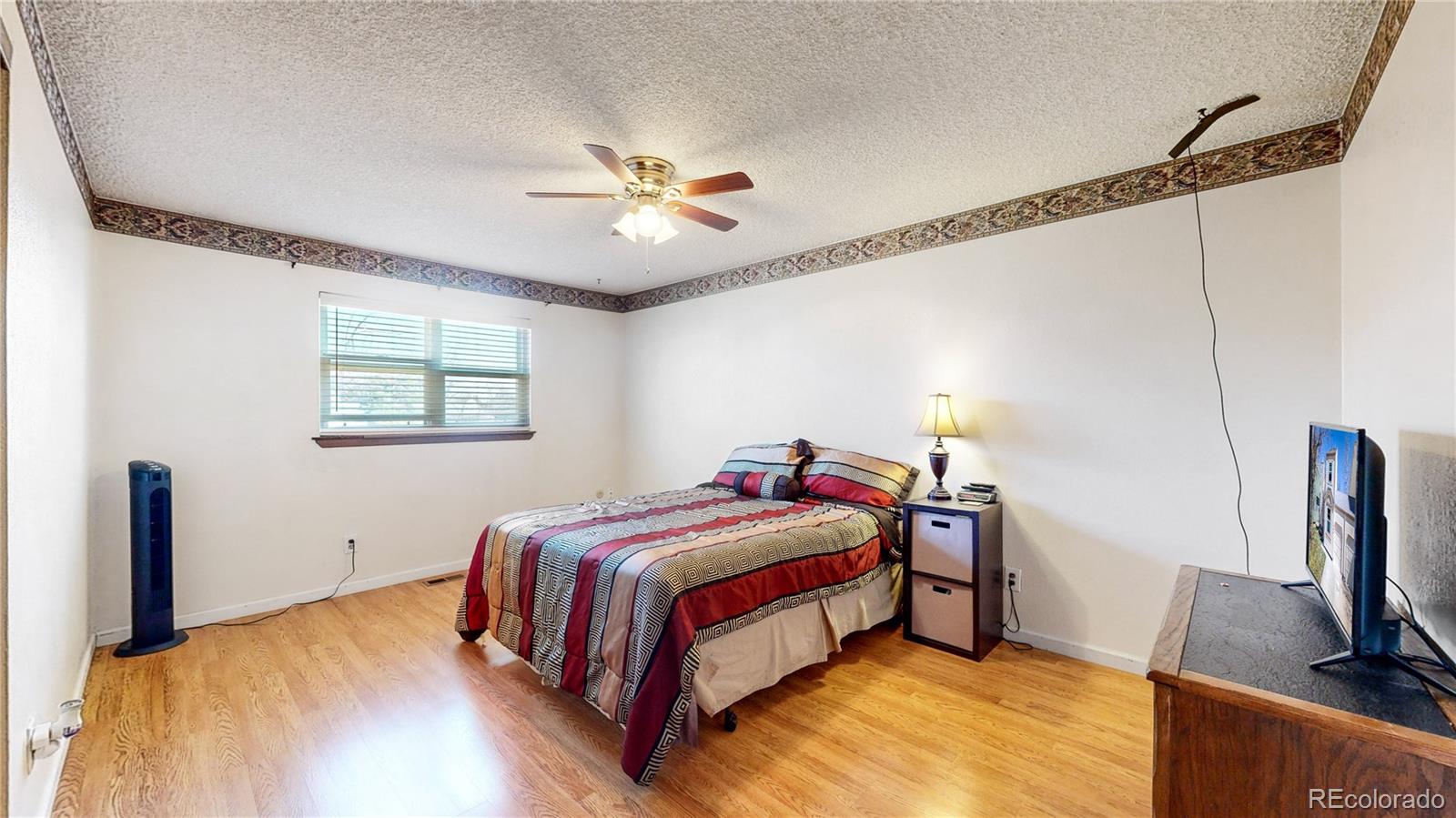 8906 Everett Street Broomfield, CO 80021 - Photo 15 of 35 a bedroom with a bed and a flat screen tv