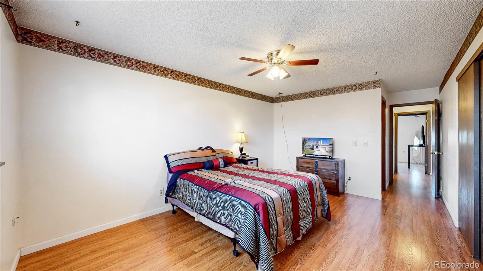 8906 Everett Street Broomfield, CO 80021 - Photo 16 of 35 a bedroom with a bed and wooden floor
