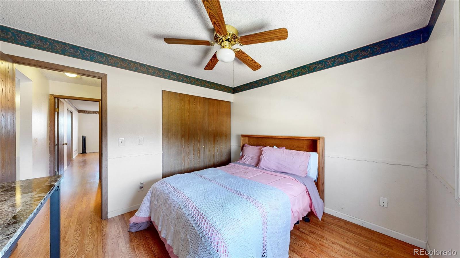 8906 Everett Street Broomfield, CO 80021 - Photo 19 of 35 a bedroom with a bed and a ceiling fan