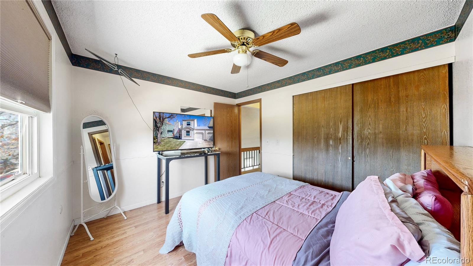 8906 Everett Street Broomfield, CO 80021 - Photo 20 of 35 a bedroom with a bed next to a window with a chandelier