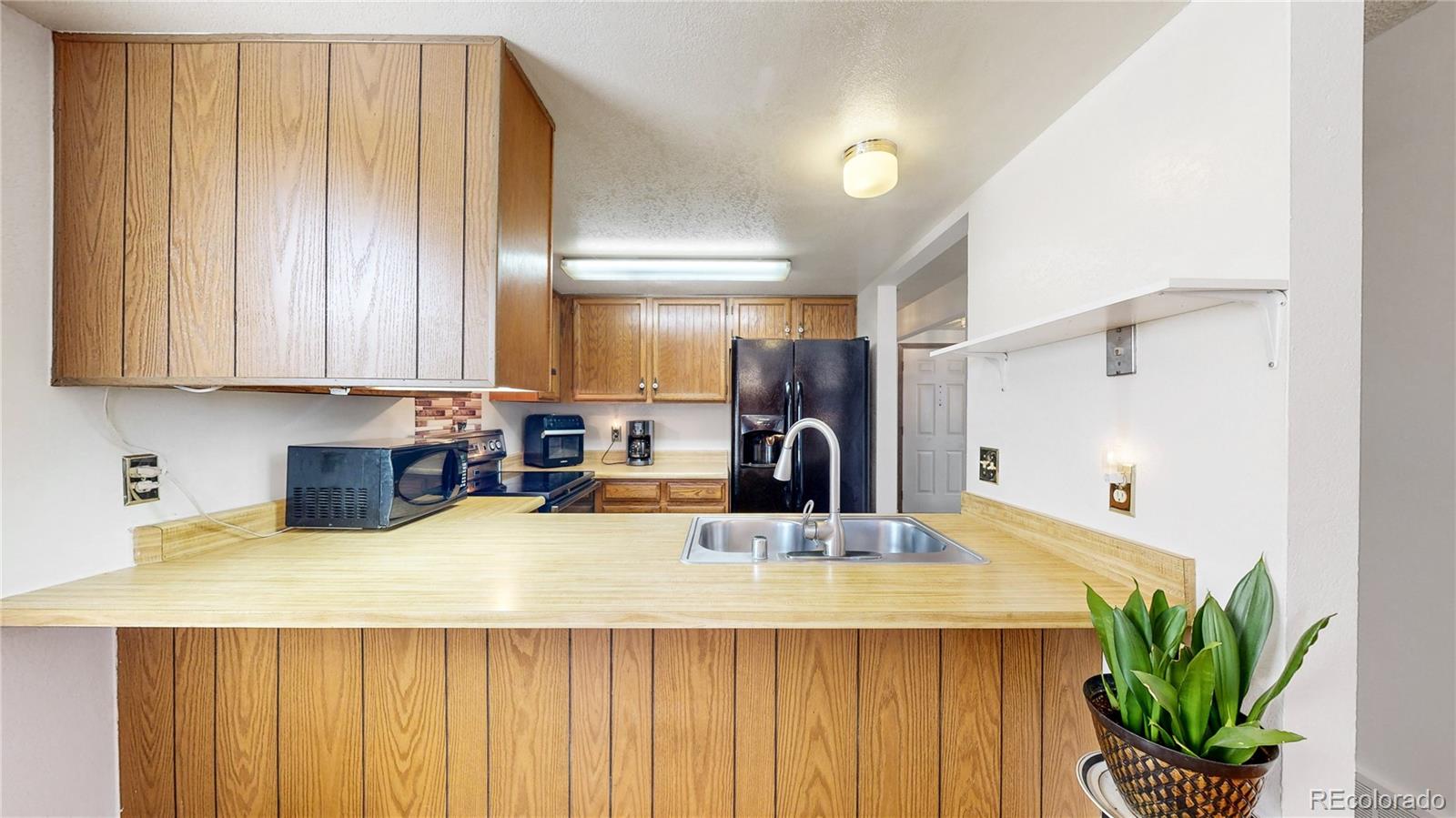 8906 Everett Street Broomfield, CO 80021 - Photo 7 of 35 a kitchen with sink a refrigerator and a counter top space