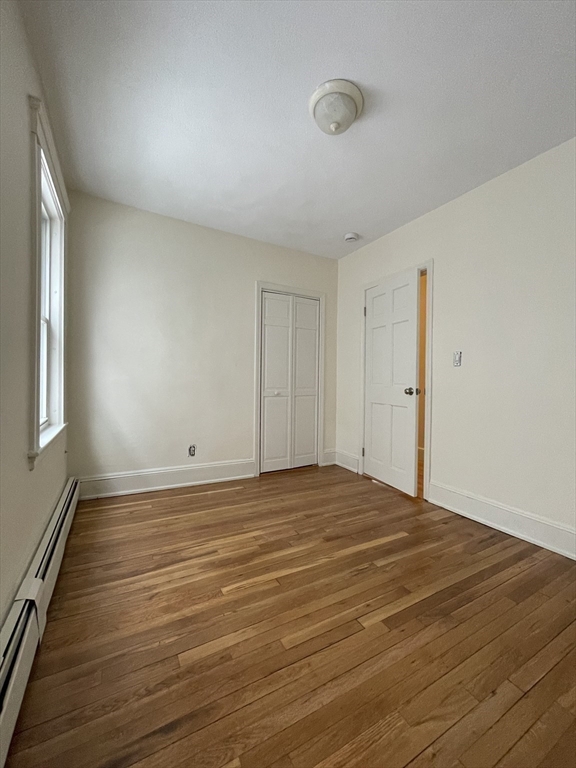 26-28 Adrian Street Somerville, MA 02143 - Photo 17 of 32 a view of empty room with wooden floor and fan
