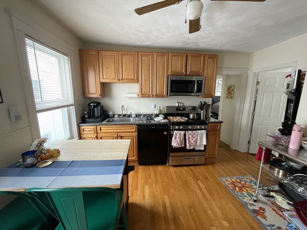 26-28 Adrian Street Somerville, MA 02143 - Photo 19 of 32 a kitchen with wooden floors sink stove and microwave