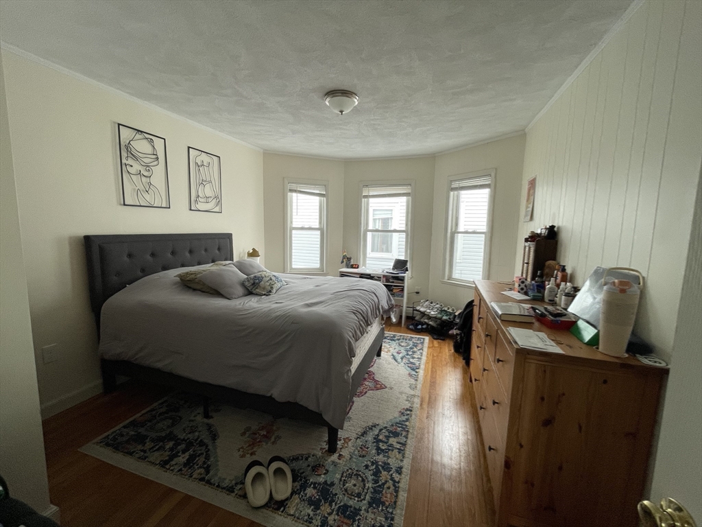 26-28 Adrian Street Somerville, MA 02143 - Photo 22 of 32 a bedroom with a bed and wooden floor