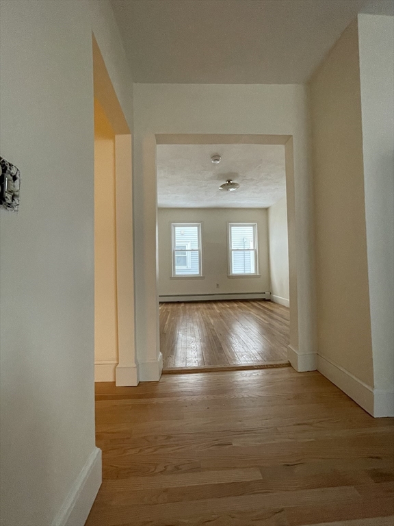 26-28 Adrian Street Somerville, MA 02143 - Photo 9 of 32 an empty room with wooden floor and windows