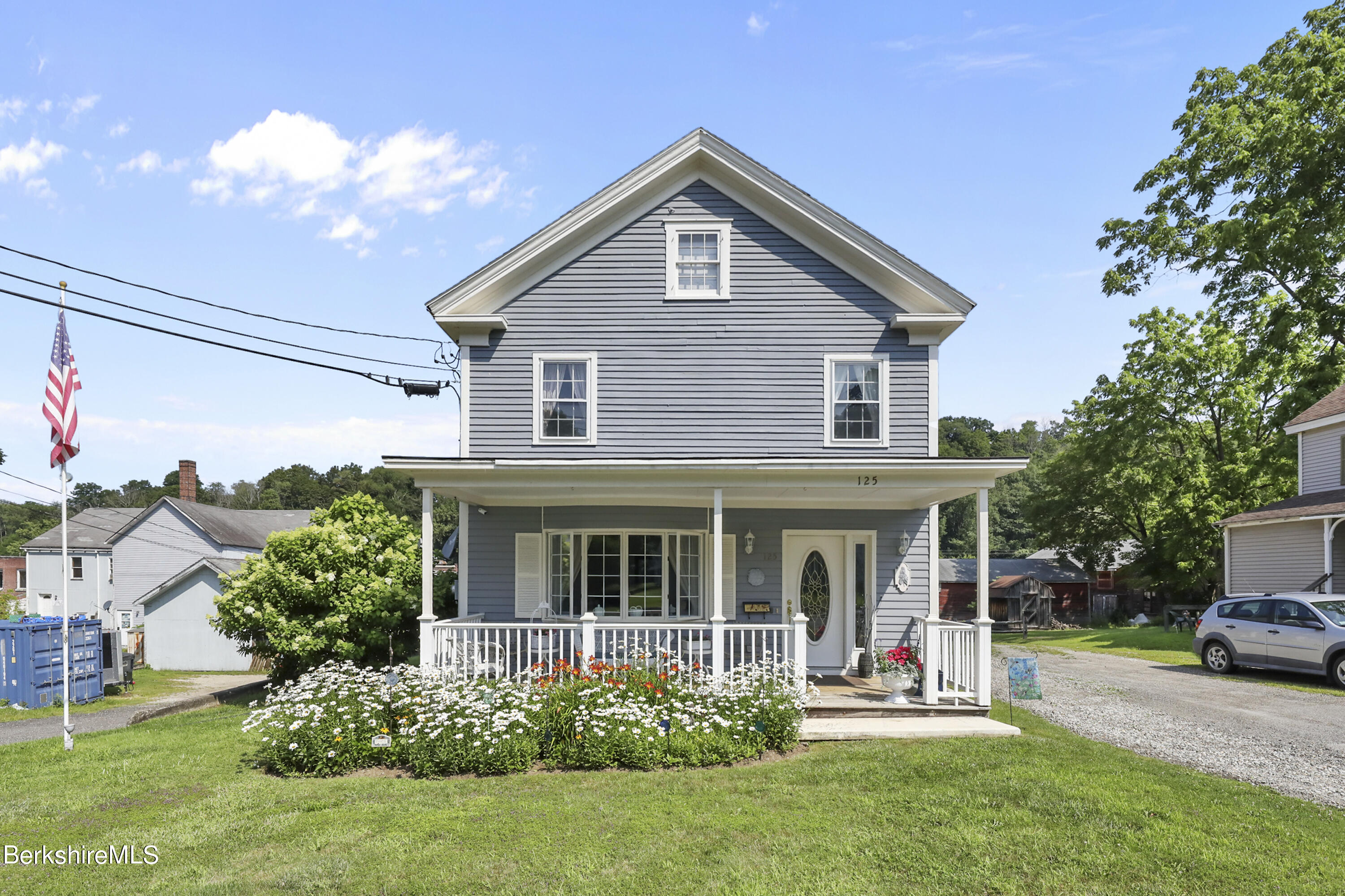 125 Center Street, Unit 2 Lee, MA 01238 - Photo 2 of 39 a front view of a house with a garden and porch