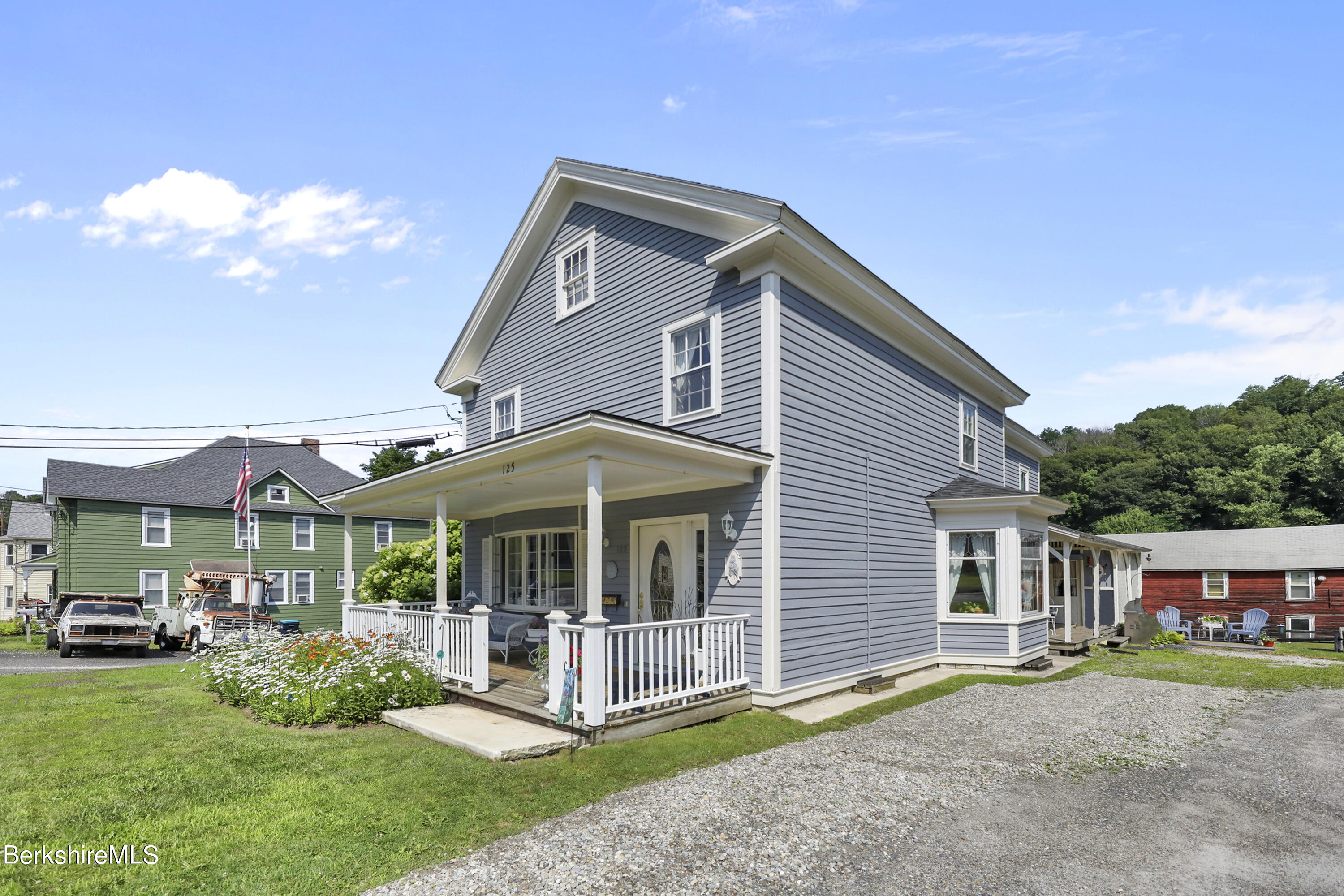 125 Center Street, Unit 2 Lee, MA 01238 - Photo 3 of 39 a front view of a house with a yard table and chairs