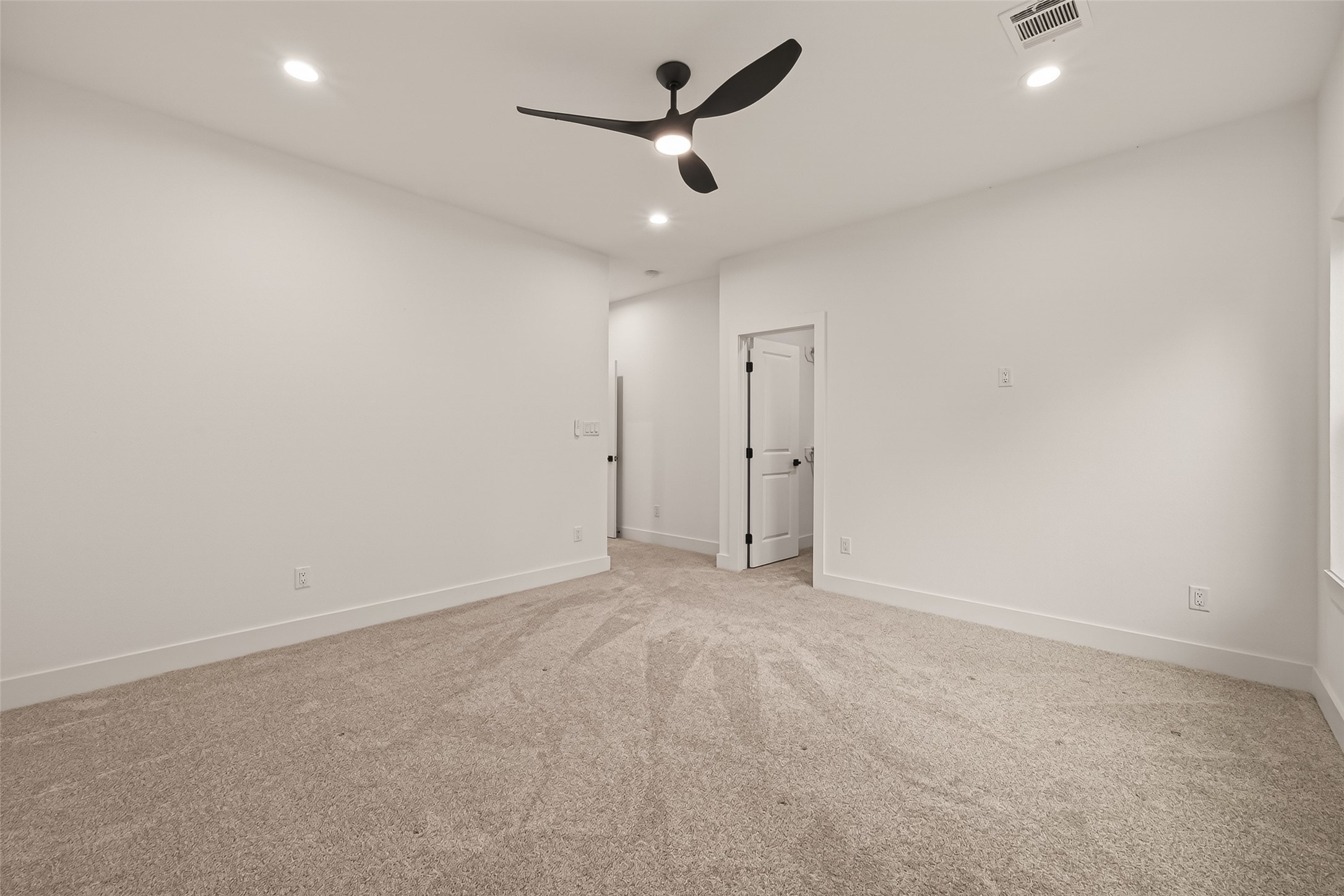 6808 Madrid Street Houston, TX 77021 - Photo 25 of 31 This room features plush carpeting, white walls, recessed lighting, and a modern ceiling fan. It has a clean, spacious feel with a door leading to another area, ideal for a bedroom or office.