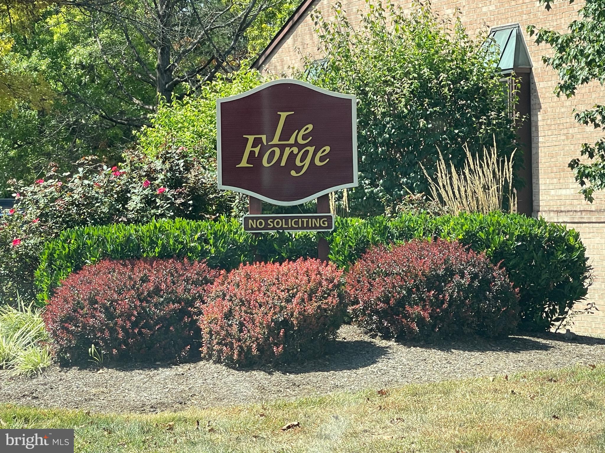 50 Le Forge Court, Unit 50 Chesterbrook, PA 19087 - Photo 2 of 17 a sign broad in front of flowers