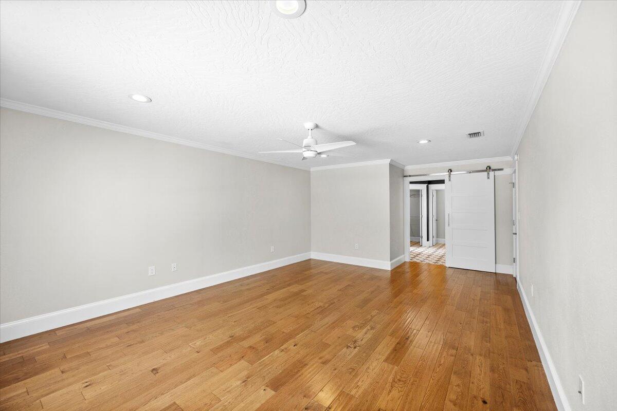 7584 Woodmont Road Navarre, FL 32566 - Photo 18 of 62 an empty room with wooden floor and ceiling fan