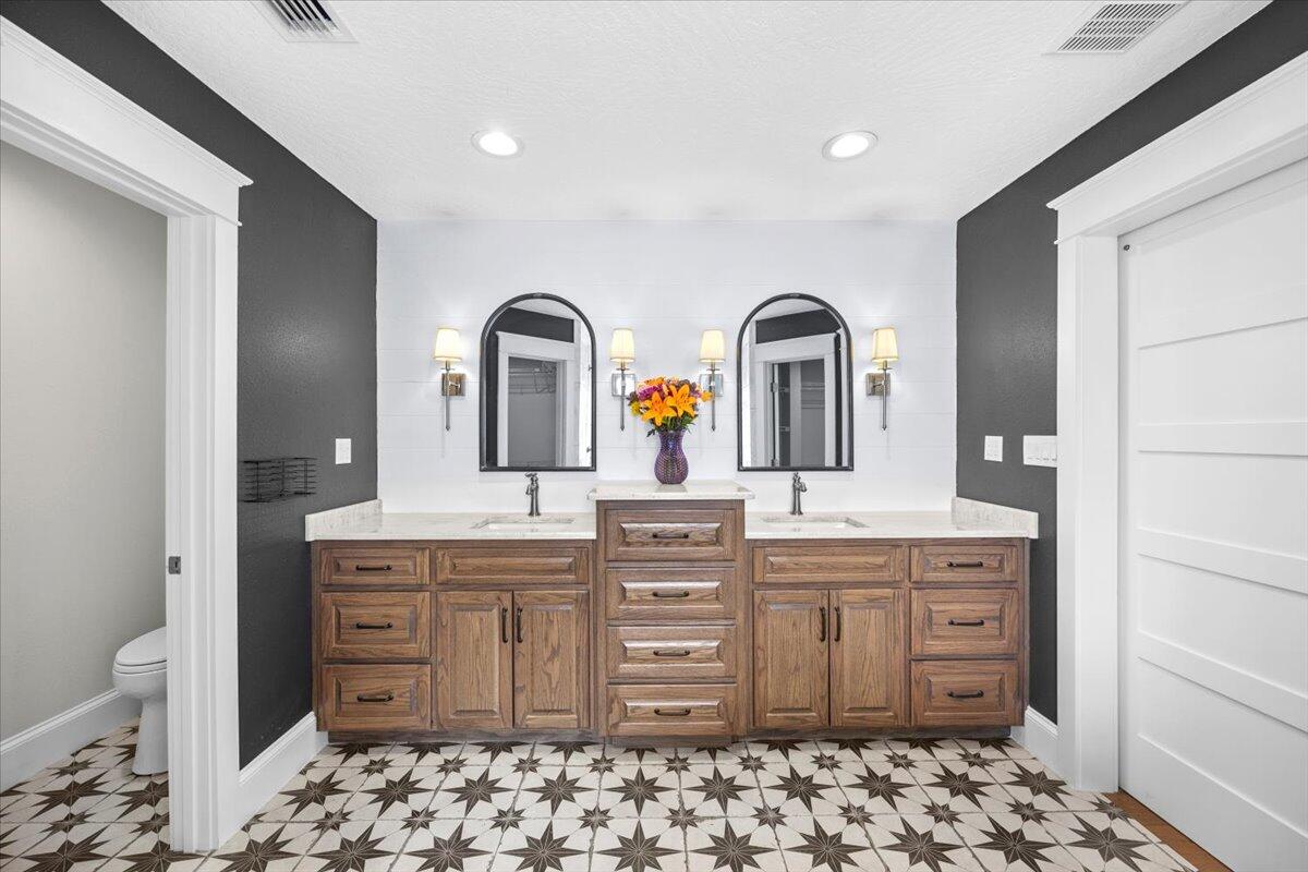 7584 Woodmont Road Navarre, FL 32566 - Photo 23 of 62 a spacious bathroom with a granite countertop sink and a mirror