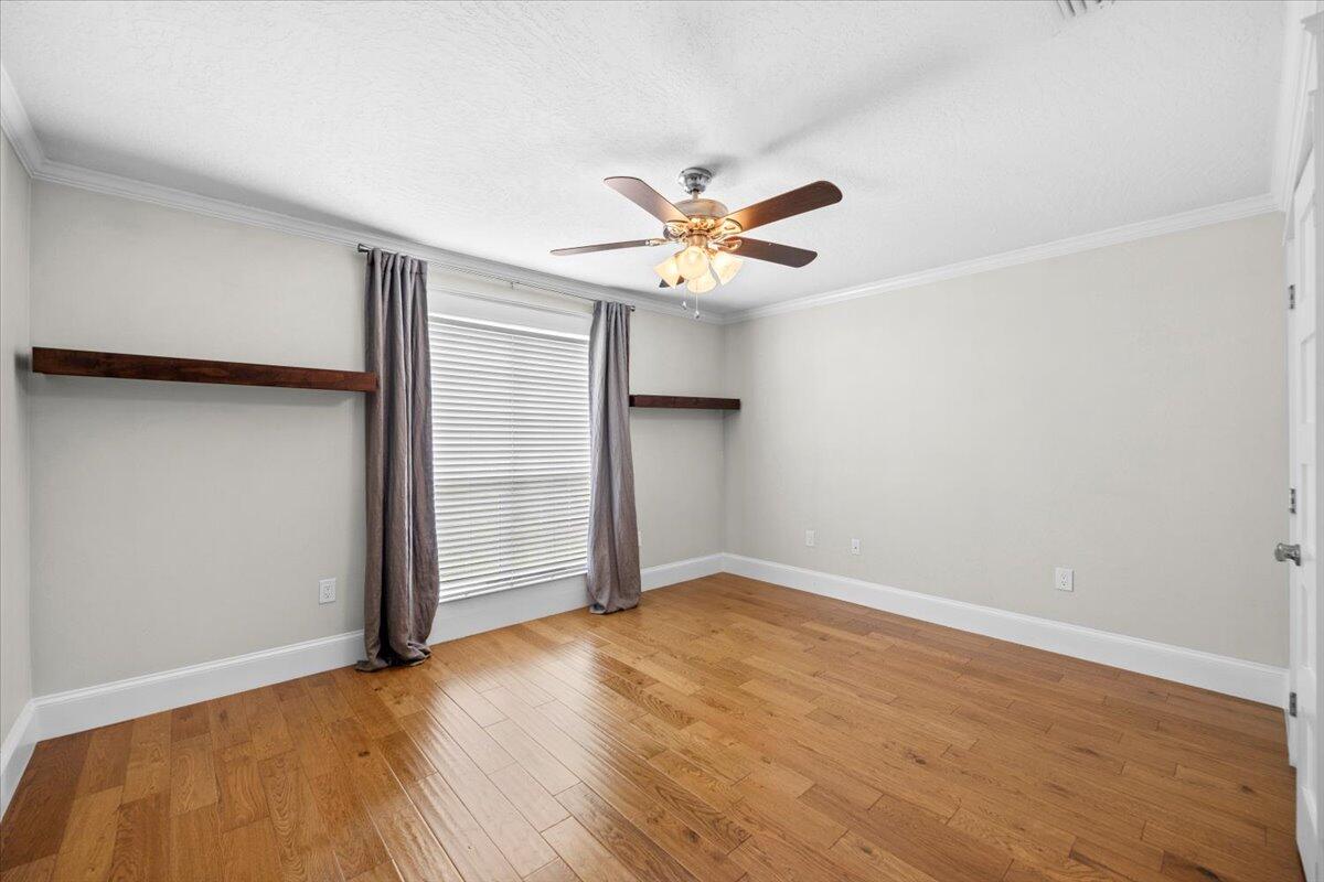 7584 Woodmont Road Navarre, FL 32566 - Photo 24 of 62 an empty room with wooden floor and a ceiling fan