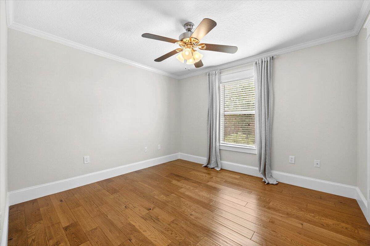 7584 Woodmont Road Navarre, FL 32566 - Photo 29 of 62 wooden floor in an empty room with a window