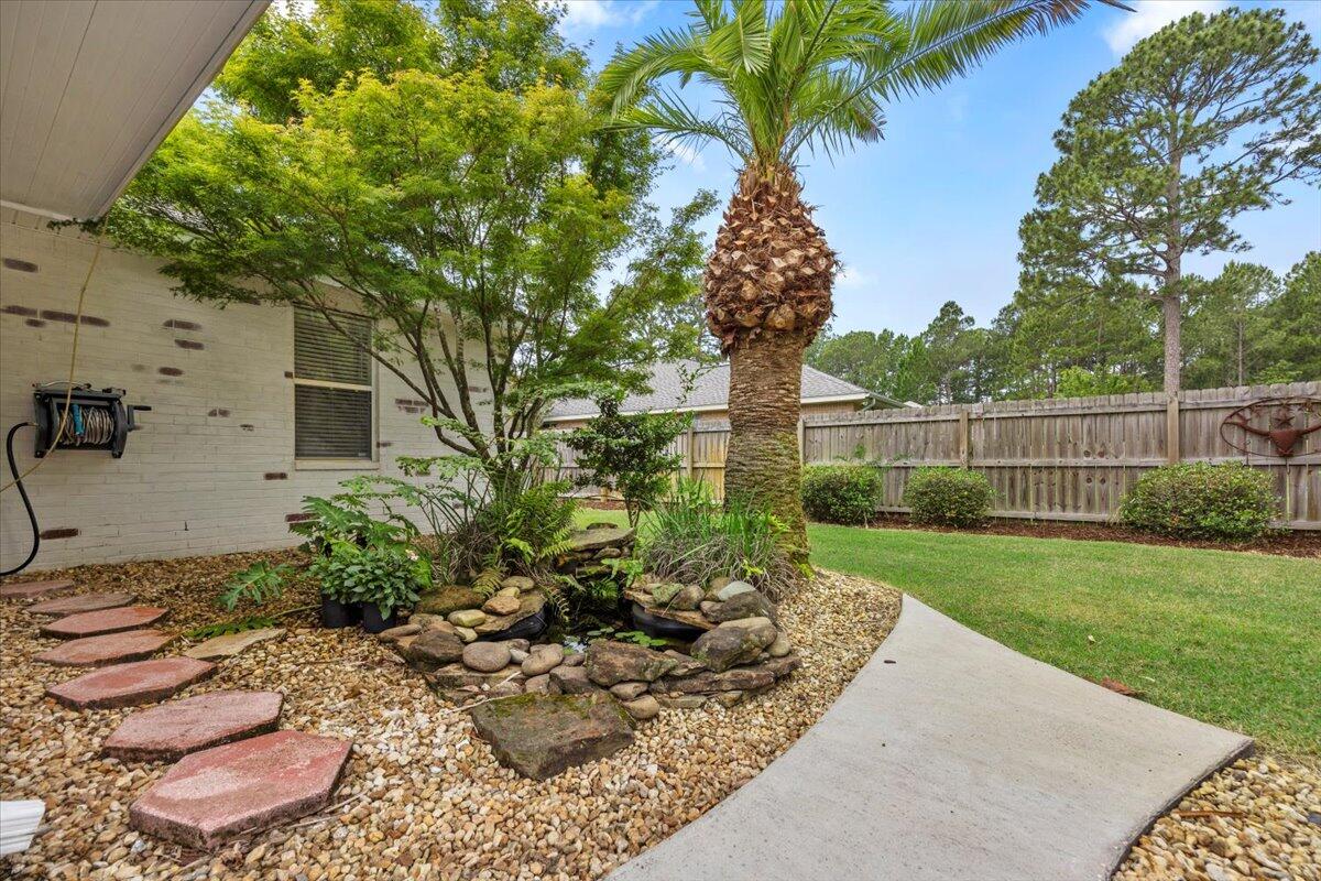 7584 Woodmont Road Navarre, FL 32566 - Photo 3 of 62 a view of a backyard with potted plants and large trees